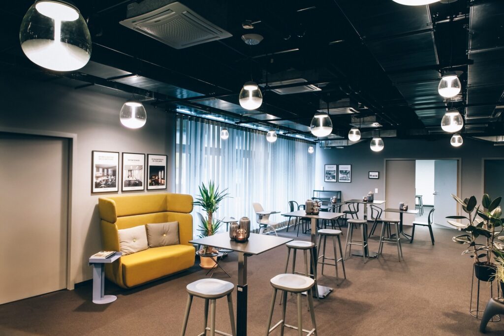 Lounge mit gelbem Sofa und Pendelleuchten von Artemide in den Design Offices Stuttgart