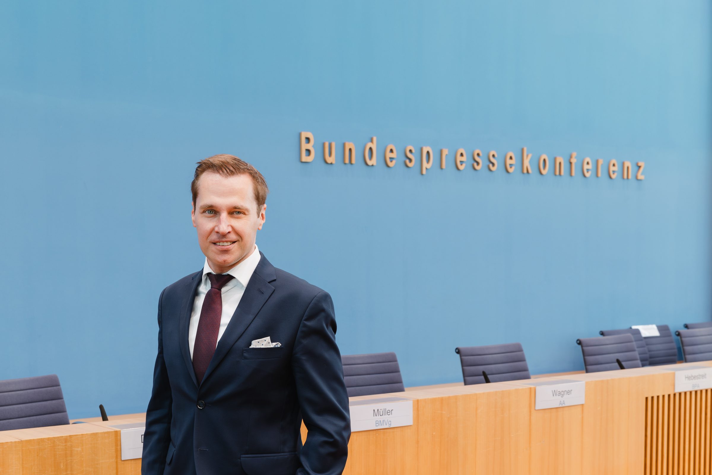Porträt eines Mannes im Anzug im Saal der Bundespressekonferenz