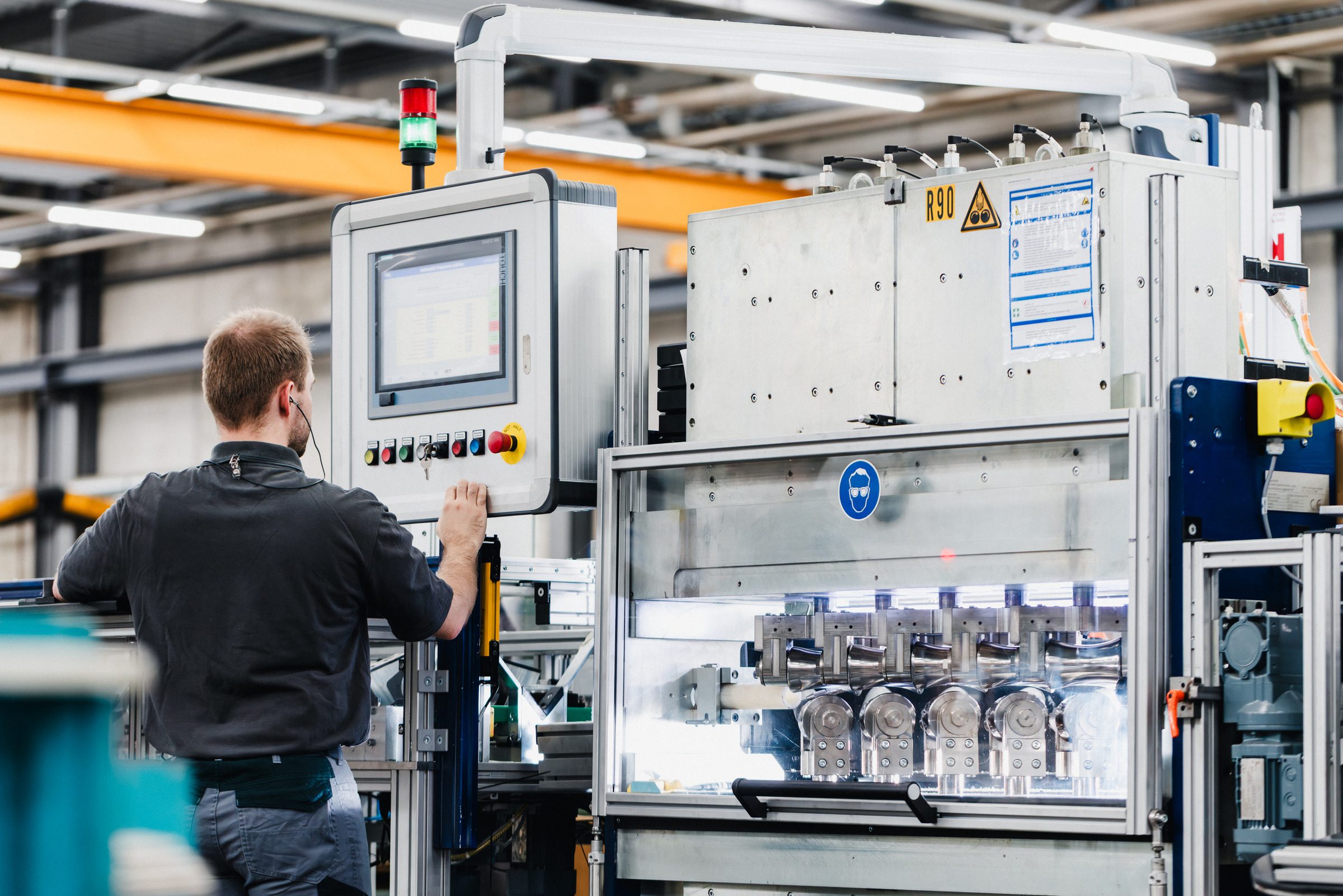 Mitarbeiter steht am Bedienpult einer Fertigungsanlage in der Produktion von Eugen Geyer