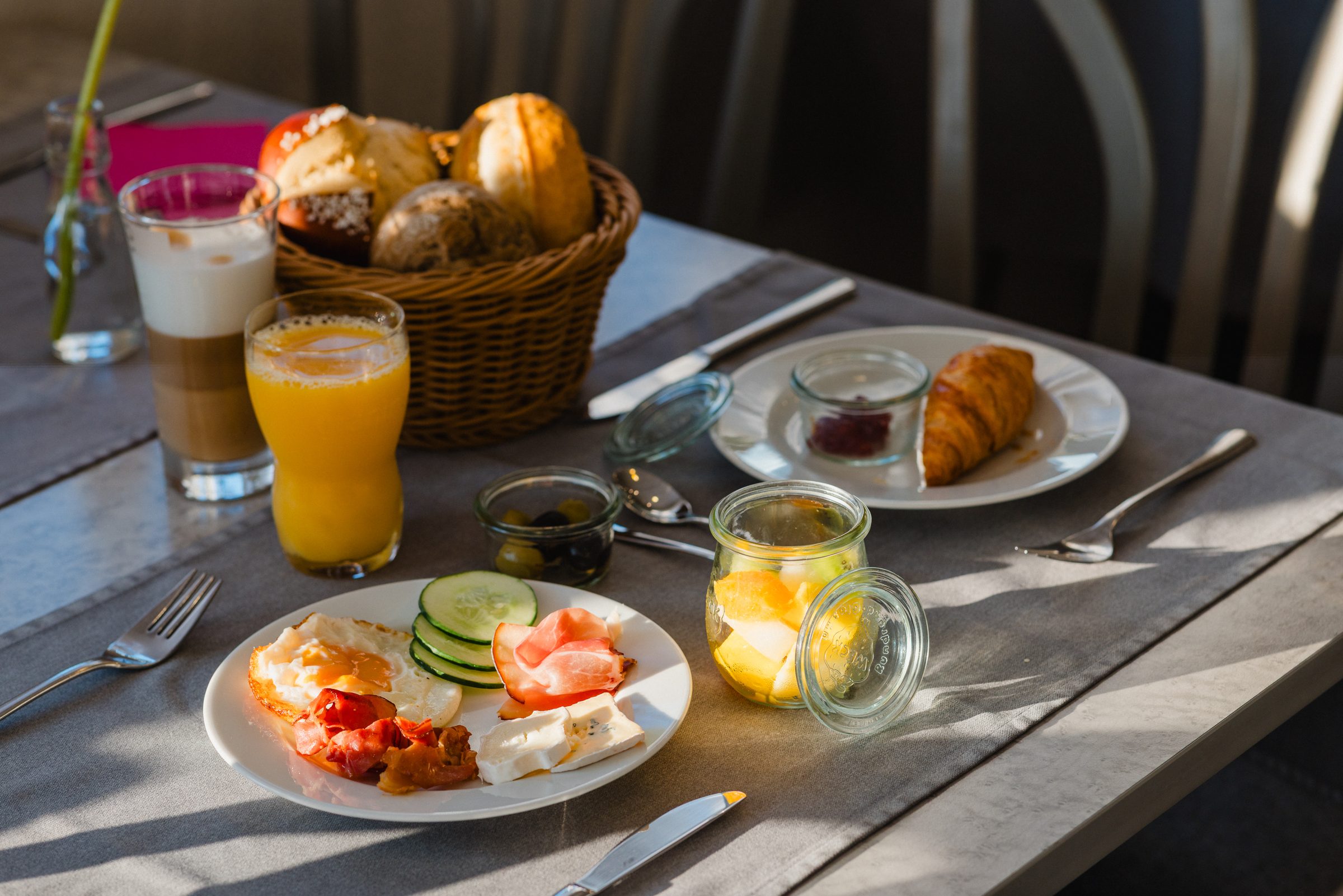 Gedeckter Frühstückstisch im Hotel Engelhorn mit Croissants, Orangensaft und einem Teller mit Ei und Gemüse