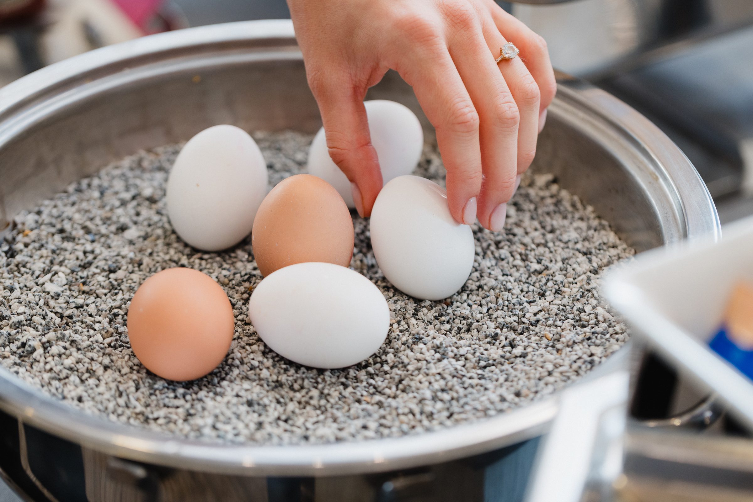 Hand nimmt ein Ei aus einem Warmhaltebehälter am Frühstücksbuffet des Hotel Engelhorn