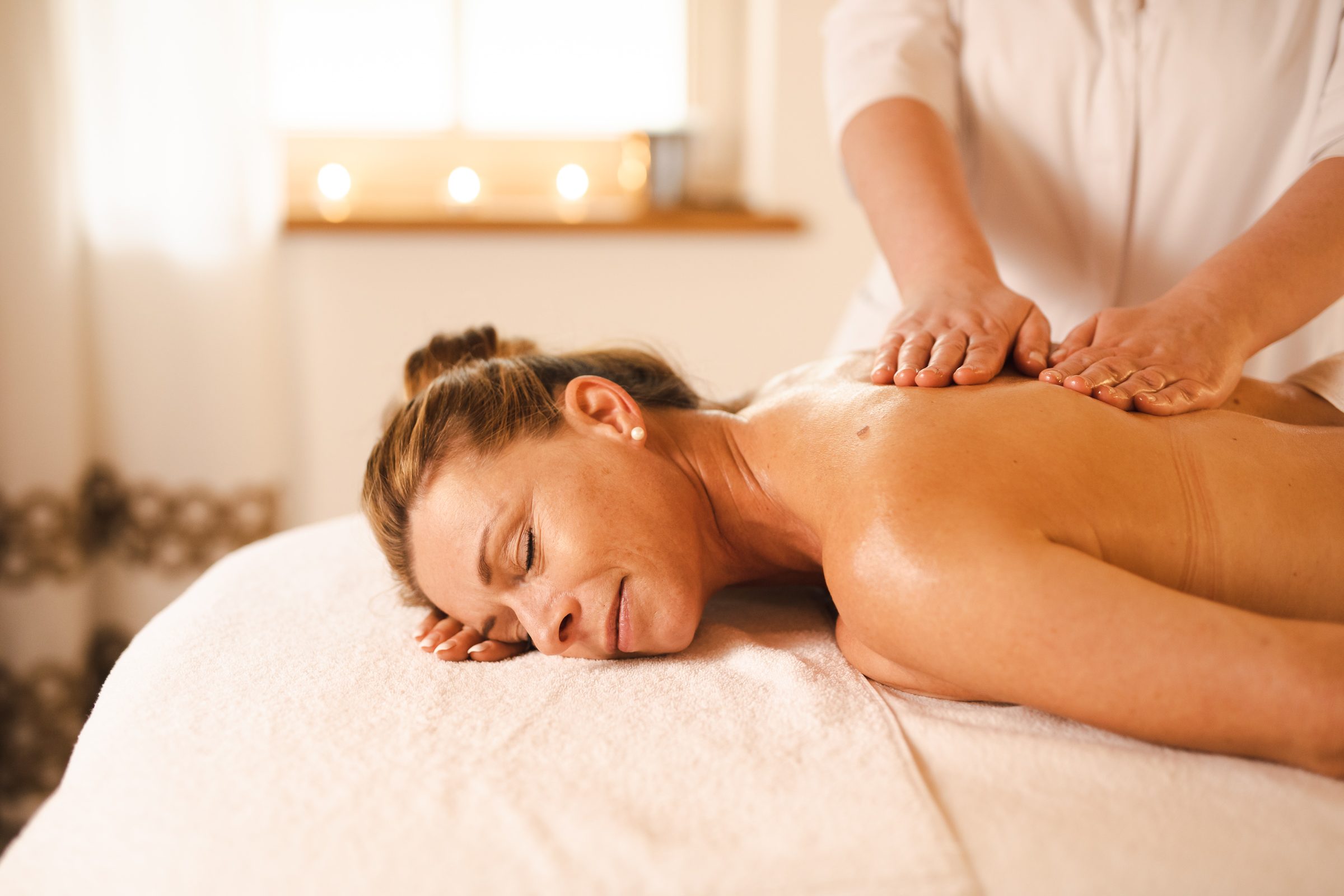 Frau liegt entspannt bei einer Rückenmassage im Spa des Hotel Krone