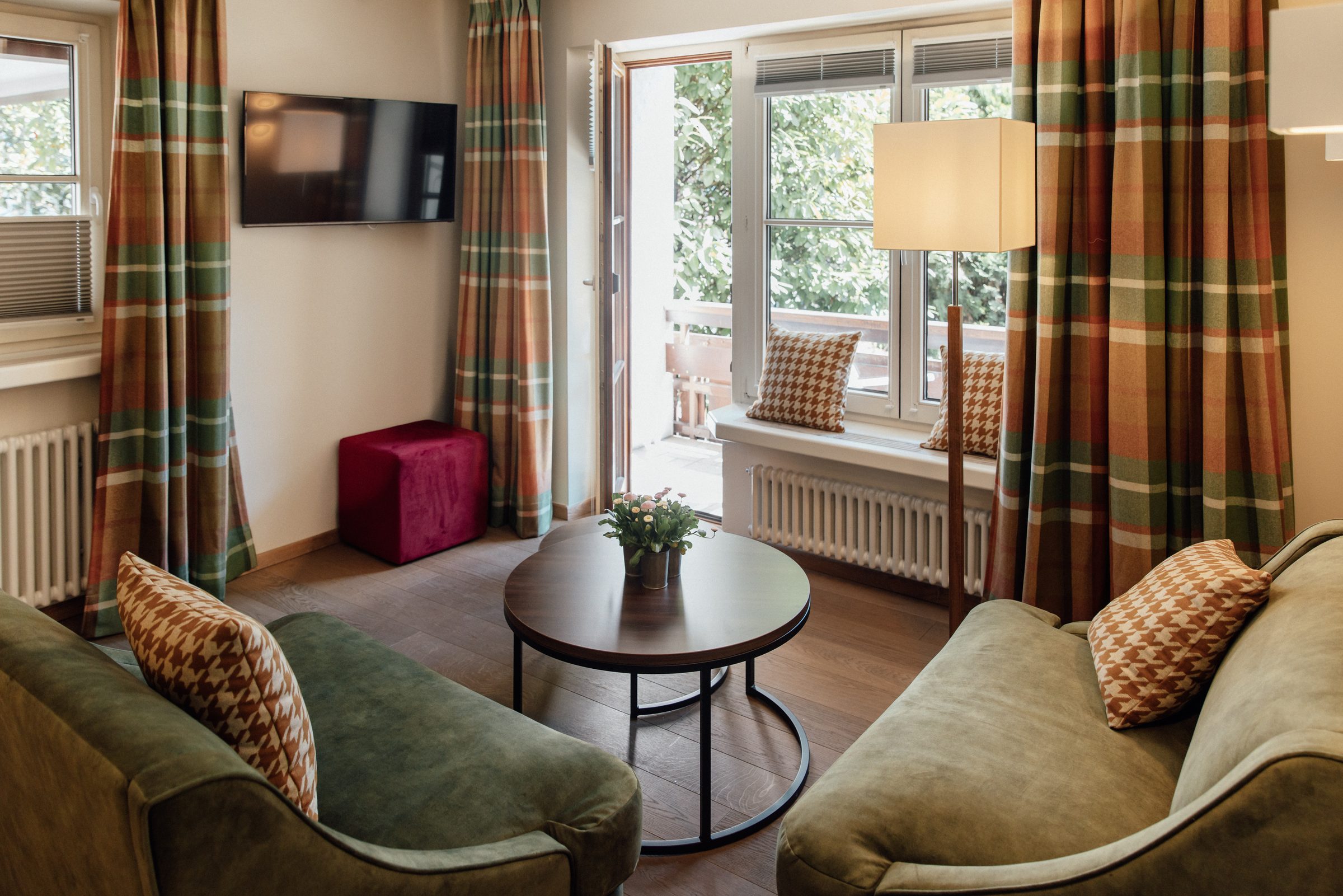 Hotelzimmer im Hotel Krone mit Sofa, Sesseln und großen Fenstern im Tageslicht
