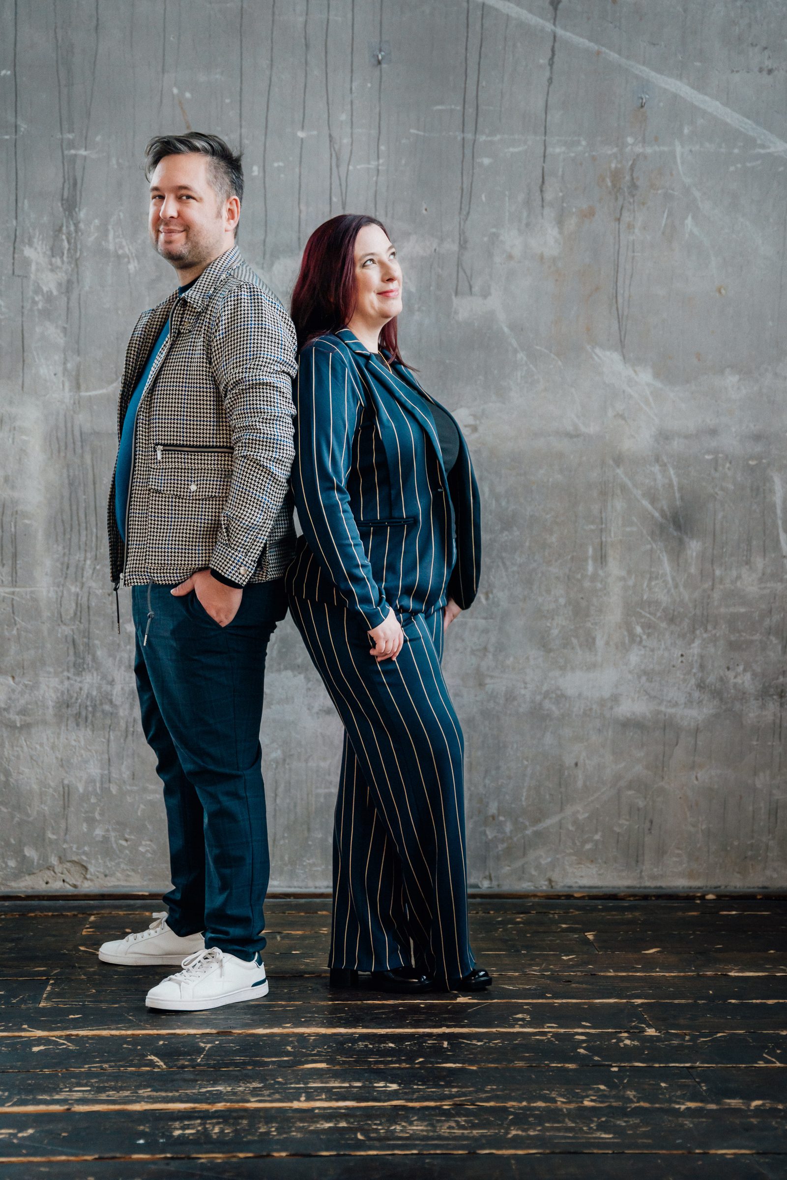 Johannes Hüsch und Anna Weber stehen Rücken an Rücken vor einer Betonwand