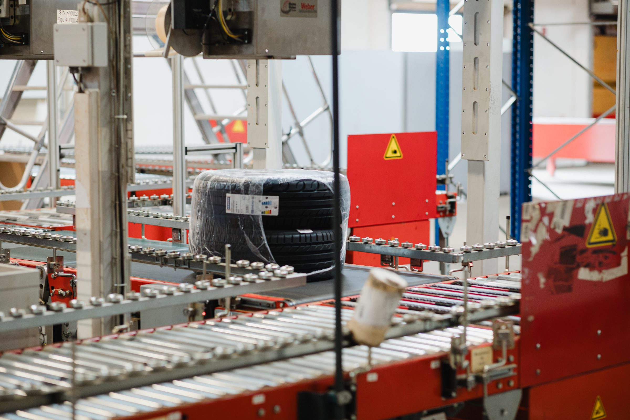 Reifen auf Rollenbahnen in der Fördertechnik der Lagerhalle von IHLE
