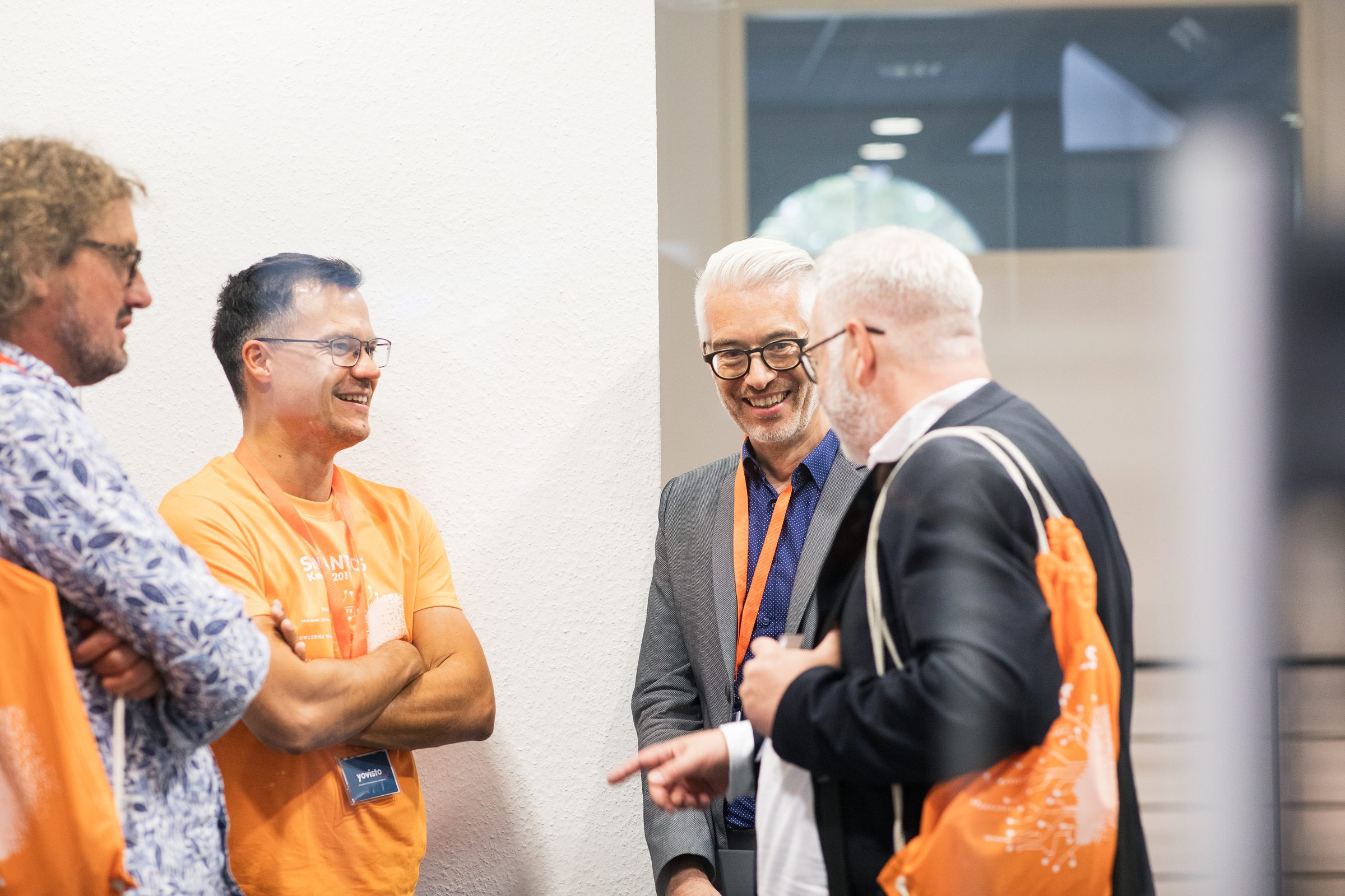Vier Männer unterhalten sich lachend am Rand der Konferenz SEMANTiCS
