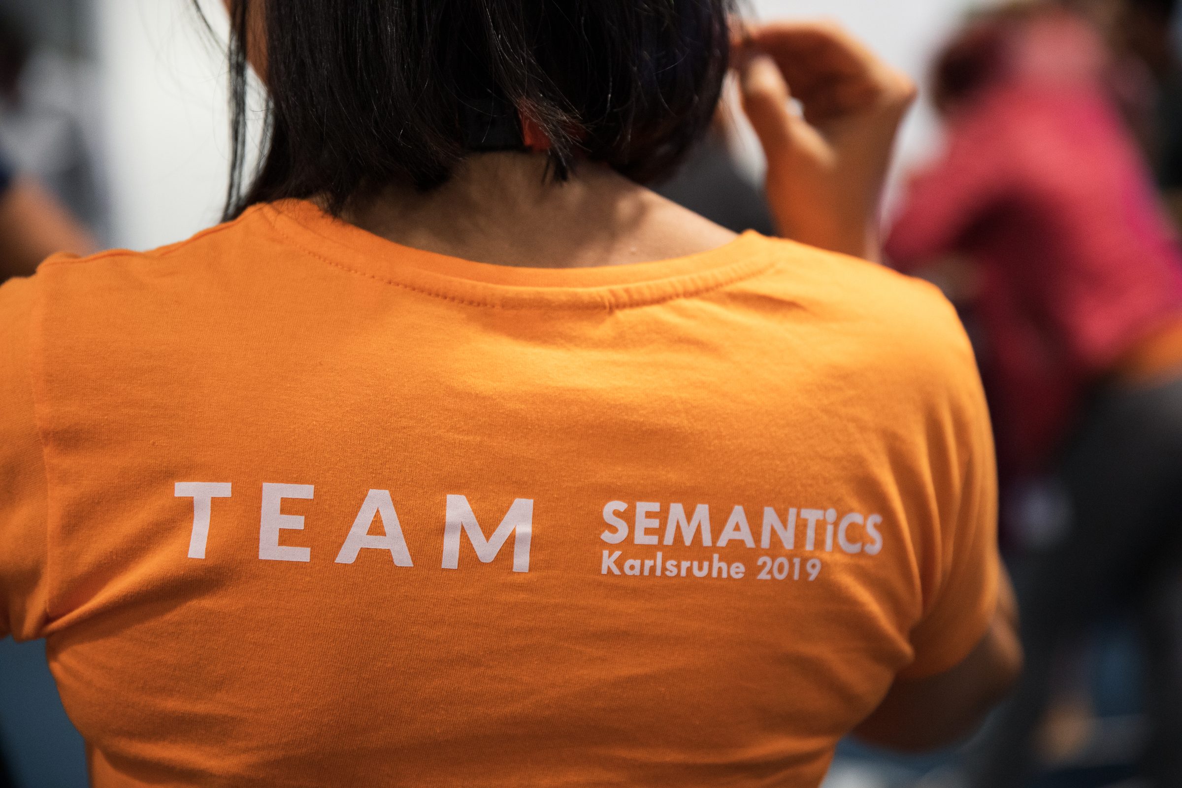 Rücken eines orangen Shirts mit der Aufschrift Team SEMANTiCS Karlsruhe 2019