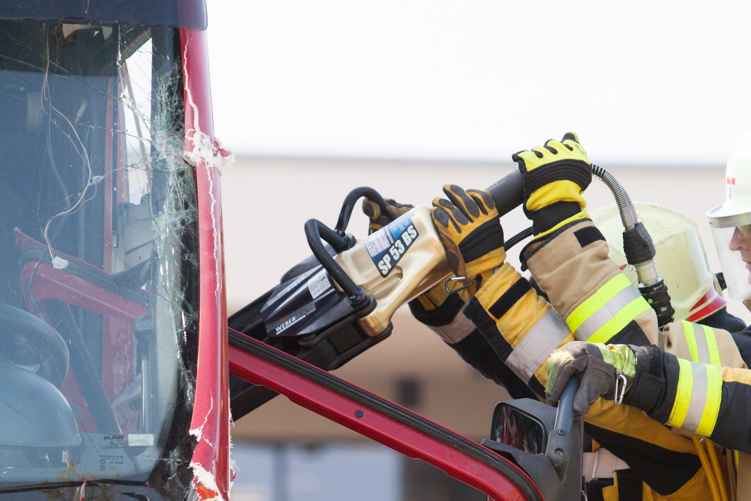 Feuerwehrleute setzen bei den Rescue Days einen hydraulischen Spreizer von Weber Hydraulik am Rahmen eines Lkw-Führerhauses an